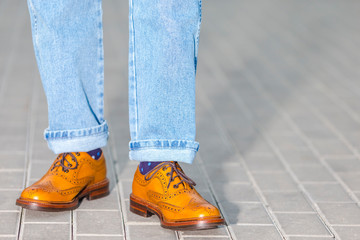 Close-up of Male Legs In Leather Brown Oxford Semi Brogues Shoes. Photographed in Motion While...