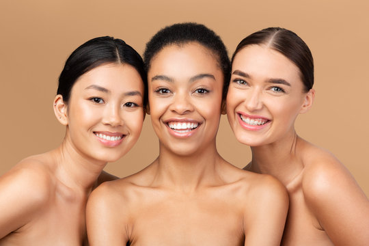 Three Multicultural Ladies Models Posing Smiling On Beige Studio Background