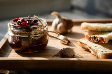 Still life with sun-dried tomatoes, garlic and bread on a sunny day.