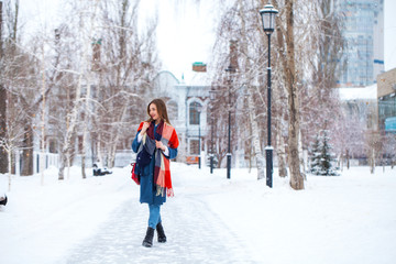 Fototapeta na wymiar Portrait of young girl in blue jeans walking in a winter park