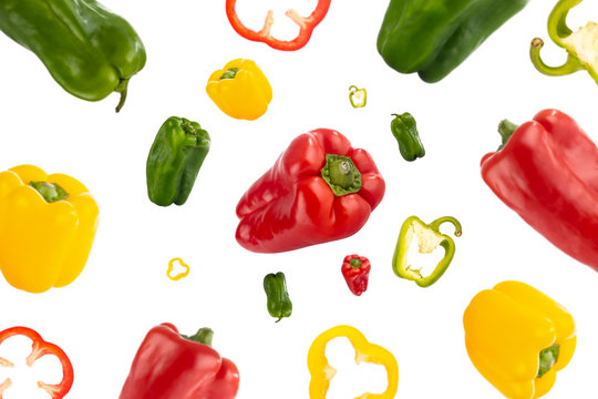 Healthy Red, Green And Yellow Peppers Flying Through The Air Isolated On White Background. Concept Of Healthy Food, Lifestyle And Wellness. Creative Pattern.