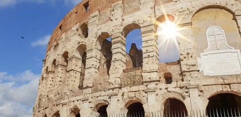 The Colosseum, Rome, Italy in Summer with sun glinting through one of the arches