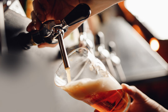 Light Draft cold beer pour in glass from crane in pub