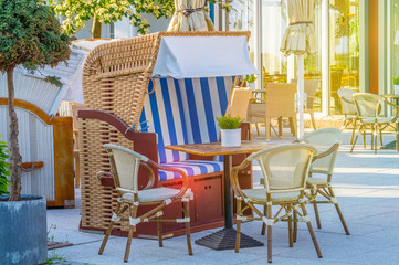 Fototapeta na wymiar A beach chair, table and chairs in resturant of a hotel near the beach of binz, ruegen, germany. Travel and vacation concept