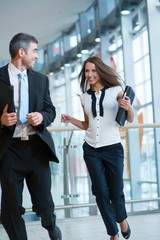 Happy businessman and businesswoman running