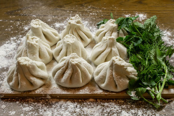 Fresh khinkali made from dough with meat inside, a national Georgian dish. Fresh dough, flour and herbs.