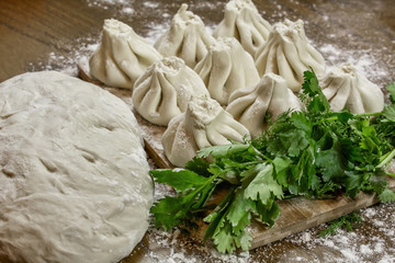 Fresh khinkali made from dough with meat inside, a national Georgian dish. Fresh dough, flour and herbs.