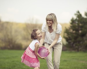 Mother and daughter playing with ball in the park