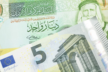 A European Union five euro bank note with a one dinar bill from Jordan, close up in macro