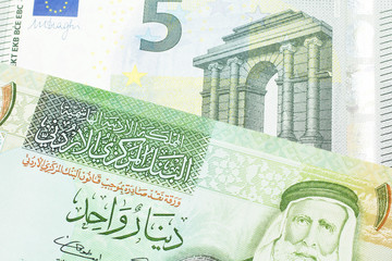 A European Union five euro bank note with a one dinar bill from Jordan, close up in macro