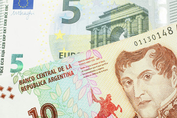 A ten peso bill from Argentina, close up in macro with a red, five Euro European bank note
