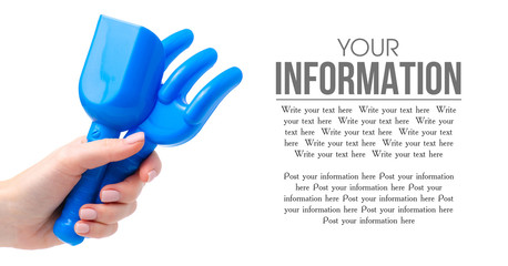 Baby blue rake shovel sandbox toys in hand on a white background isolation, space for text