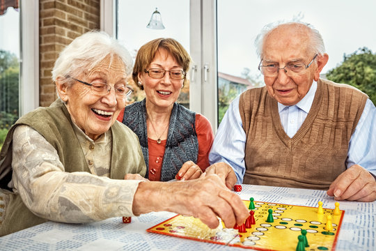 Elderly Couple and Daughter Playing Board Game