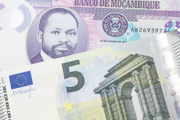 A purple, twenty metical note from Mozambique close up with a red, one hundred European euro note
