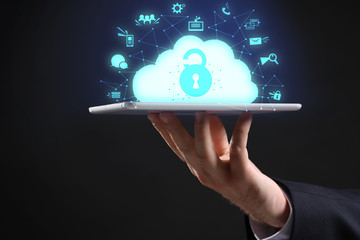 Hand of businessman with tablet computer and hologram projection of cloud storage service against...