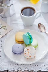 Breakfast with French colorful macarons with coffee cup