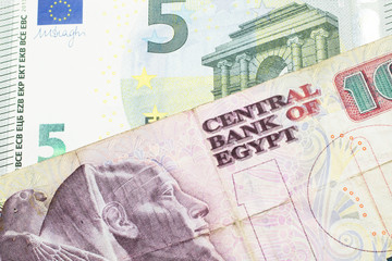 A ten Egyptian pound bill with a blue and green five euro note from France close up in macro