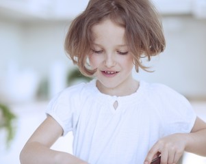 Close-up portrait of young girl chopping food in kitchen