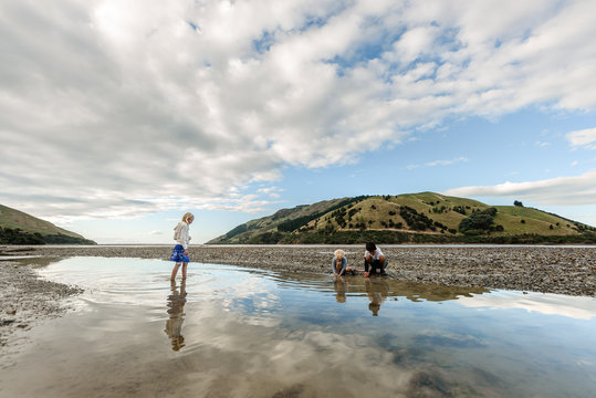 Children playing in shallow water at low tide in New Zealand