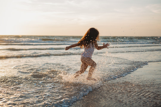 Child splashing and running in the surf along the beach in Florida