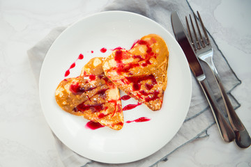 pancakes in the shape of a heart with berry jam