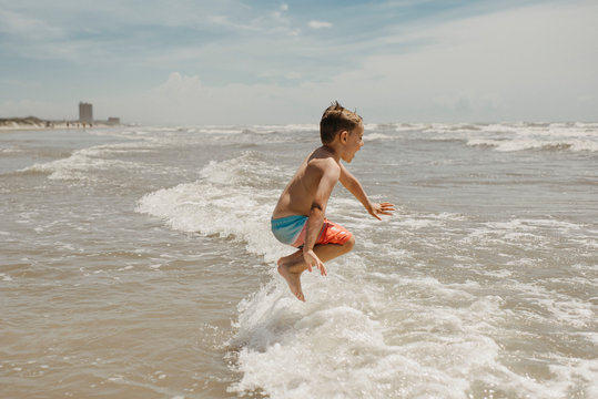 Boy Jumping in Ocean Waves at Beach in Corpus Christi Texas