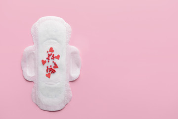 Menstrual pad with red beads on color background. Menstruation concept