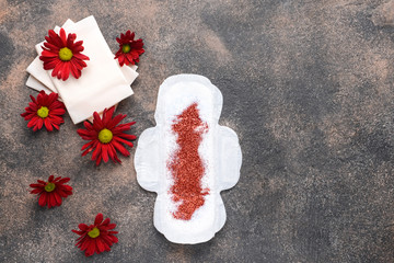 Menstrual pads with flowers and glitter on grey background. Menstruation concept © Pixel-Shot