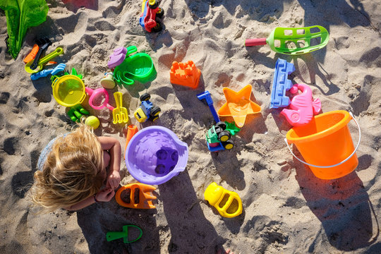 view from above of little girl and all her beach toys spread out