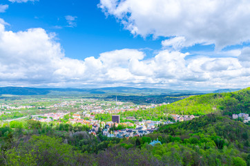 Fototapeta na wymiar Top aerial panoramic view of Karlovy Vary (Carlsbad) spa town with colorful beautiful buildings, Slavkov Forest with green trees and Ore Mountain range background, West Bohemia, Czech Republic