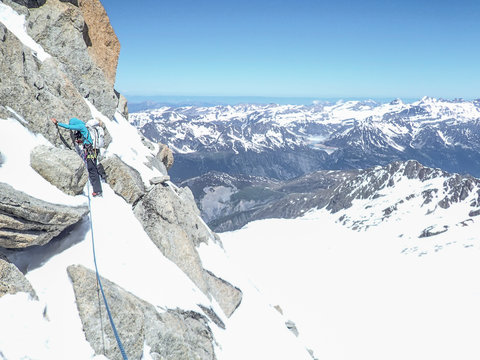 A woman alpinist focuses while in steep, unprotectable terrain