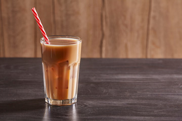 Transparent Glass Of Cold Coffee On Wooden Background. Close up.