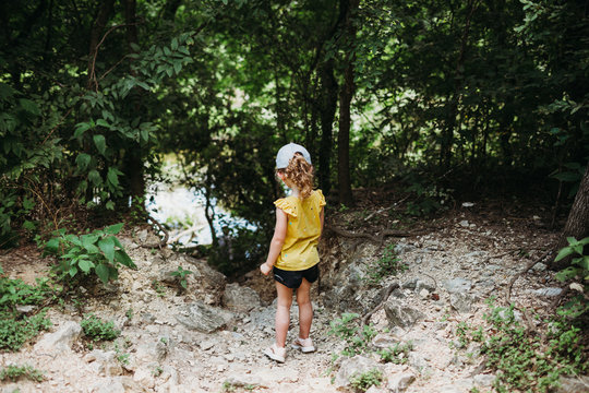 Young girl hiking near Barton Springs and looking at water
