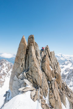 A seasoned alpinist rappels a spectacular gendarme on the Forbes Ridge