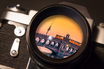 Reflection of Berlin's Oberbaum Bridge in the Lens of a Vintage SLR Camera