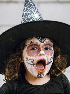 Girl screaming with face painted and disguised for Halloween