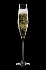 Glass for champagne with splashes isolated on black background.