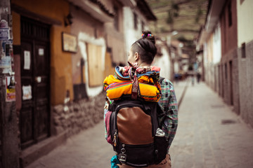 Portrait of funky female traveler with back pack and colourful fabric