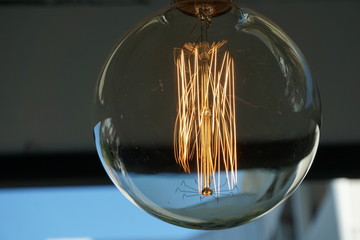 Obraz premium Amazing spiral electric current inside a retro crystal clear light bulb.