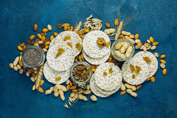 American puffed rice cakes. Healthy snacks with ears of wheat on classic blue concrete surface, top view, flat lay, copy space for you text.