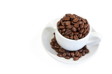 White coffee cup on saucer and roasted beans isolated on white background . Close up.