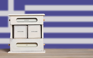 Wooden retro calendar with free space for a date on the background of the flag of Greece. Template for writing the dates of the national holidays of Greece with free text space