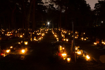 Fototapeta na wymiar Christmas night at the Hietaniemi cemetery in Helsinki with Christmas lights, lanterns and candles that are traditionally lit in the cemetery on Christmas night in Finland.