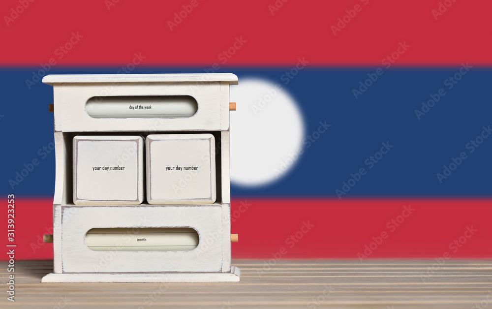 Fototapete wooden retro calendar with free space for a date on the background of the flag of laos. template for