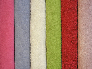 Fototapeta premium Colorful textile background of rolls of colored terry towels