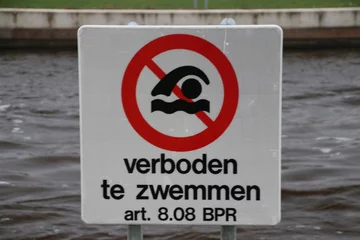 Fototapeten Sign with warning that swimming is not allowed in the water in the dutch language 'Verboden te zwemmen' © André Muller