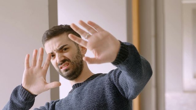 young serious man pushing something away disgusted