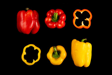 Collage set of fresh whole and sliced yellow and red  bell peppers (paprika) isolated on a black background. Top view