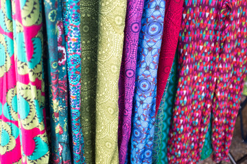 background of colourful fabric hanging vertically 