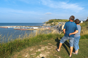 Couple watching the city of Port-en-Bessin in Normandy